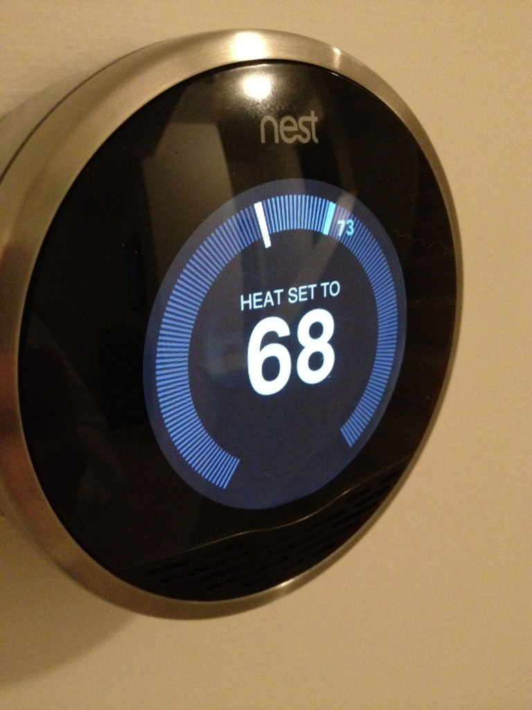 Nest smart thermostat set to 68 degrees Fahrenheit warming a home efficiently